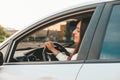 Young happy millennial brunette woman driving car. Young attractive woman in the car. Woman drive an auto. Close up Royalty Free Stock Photo