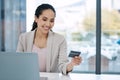 Young happy mixed race businesswoman using a credit card and working on a laptop in an office. Hispanic businessperson Royalty Free Stock Photo