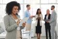 Young happy mixed race businesswoman working on a digital tablet in an office. One joyful hispanic female boss with a Royalty Free Stock Photo