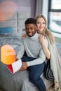 Happy interracial couple spending weekend together at home, relaxing with book Royalty Free Stock Photo