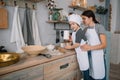 Young happy mom and her baby cook cookies at home in the kitchen. Christmas Homemade Gingerbread. cute boy with mother in white Royalty Free Stock Photo