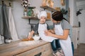 Young happy mom and her baby cook cookies at home in the kitchen. Christmas Homemade Gingerbread. cute boy with mother in white Royalty Free Stock Photo