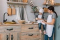 Young happy mom and her baby cook cookies at home in the kitchen. Christmas Homemade Gingerbread. cute boy with mother in white Royalty Free Stock Photo