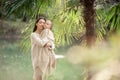 Young and happy mother cares for her young son, and walks along the shore of the lake in the summer in the park Royalty Free Stock Photo