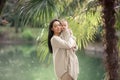 Young and happy mother cares for her young son, and walks along the shore of the lake in the summer in the park Royalty Free Stock Photo