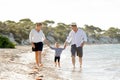 Young happy mother and father walking on beach in family vacation concept Royalty Free Stock Photo