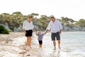 Young happy mother and father walking on beach in family vacation concept Royalty Free Stock Photo