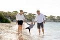 Young happy mother and father walking on beach in family vacation concept Royalty Free Stock Photo