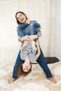 Young happy mother having fun with her cute little baby holding her upside down Royalty Free Stock Photo