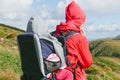 Young happy mother hold little traveller on back - baby girl in