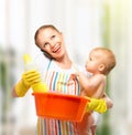 Young happy mother is a housewife with a baby does homework and Royalty Free Stock Photo