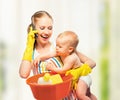 Young happy mother is a housewife with a baby does homework and Royalty Free Stock Photo