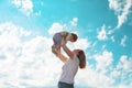 Young happy mother throws up baby in the sky. Side view. Bottom view. Copy space. Concept of happy childhood Royalty Free Stock Photo