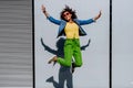 Young happy multiracial teenage girl with sunglasses and afro hairstyle, jumping and posing outdoor. Royalty Free Stock Photo