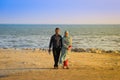 Young happy muslim Iranian couple in love are walking together on the beach