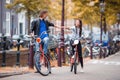 Young happy caucasian couple on bikes in old streets in Amsterdam Royalty Free Stock Photo