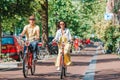 Young happy caucasian couple on bikes in old streets in Amsterdam Royalty Free Stock Photo