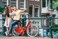 Young happy caucasian couple on bikes in old streets in Amsterdam Royalty Free Stock Photo