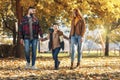 Happy parents having fun with their boy while running in the park during autumn day Royalty Free Stock Photo