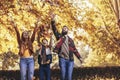 Happy parents having fun with their boy while running in the park during autumn day Royalty Free Stock Photo