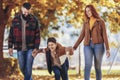 Happy parents having fun with their boy while running in the park during autumn day Royalty Free Stock Photo