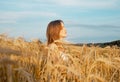 Young happy peaceful woman inside golden wheat field in summer. Meditation and peace concept