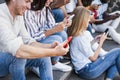 Young happy people using mobile phones outdoor in the city - Focus on left man hand holding smartphone Royalty Free Stock Photo