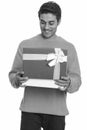 Young happy Persian man opening gift box ready for Valentine`s day Royalty Free Stock Photo