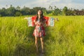 Young happy and playful Asian Chinese woman in beautiful dress having fun enjoying holidays excursion on grass tropical field smil Royalty Free Stock Photo