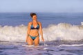 Young happy and playful red hair woman in bikini swimming on the sea playing with big waves enjoying Summer holidays paradise Royalty Free Stock Photo