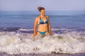 Young happy and playful red hair woman in bikini swimming on the sea playing with big waves enjoying Summer holidays paradise Royalty Free Stock Photo