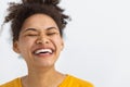 young happy positive woman with white teeth smiling broadly keeps eyes closed on white background Royalty Free Stock Photo