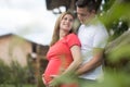 Young happy pregnant couple hugging at countryside by hayrack. Royalty Free Stock Photo