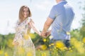 Young happy pregnant couple in love holding hands, relaxing in meadow. Royalty Free Stock Photo