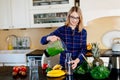 Young happy pregnant woman pouring green smoothie to glass cup Royalty Free Stock Photo