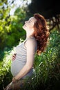 Young happy pregnant woman relaxing and enjoying life in nature. Royalty Free Stock Photo