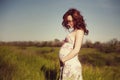 Young happy pregnant woman relaxing and enjoying life in nature.