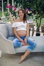 Young happy pregnant woman sitting on sofa Royalty Free Stock Photo