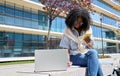 Happy African girl student using laptop and phone elearning in university park. Royalty Free Stock Photo