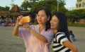 Young happy and pretty Asian Chinese girl on the beach taking selfie photo with her mother, a 60s mature woman , enjoying Summer Royalty Free Stock Photo