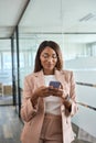 Young happy professional business woman using mobile phone in office, vertical. Royalty Free Stock Photo