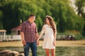 Young happy romantic pregnant couple are walking on nature near lake in summer park. Pregnant woman expecting a baby. Future mom Royalty Free Stock Photo