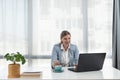 Young happy satisfied successful businesswoman manager and executive sitting in office casually working on laptop computer Royalty Free Stock Photo