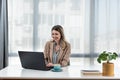 Young happy satisfied successful businesswoman manager and executive sitting in office casually working on laptop computer Royalty Free Stock Photo