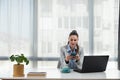 Young happy satisfied successful businesswoman manager and executive sitting in office casually working on laptop computer Royalty Free Stock Photo