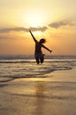 Young happy Asian woman in bikini jumping excited on sunset beach having fun Royalty Free Stock Photo