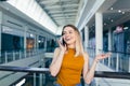 Young happy after shopping woman talking on cell in mall. Satisfied joyful female shopaholic with gift colored paper bags in hands Royalty Free Stock Photo