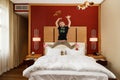 Young happy small Caucasian girl fooling jumping in the air with her toys above the bed in bedroom Royalty Free Stock Photo