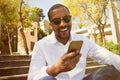 Young happy smiling african american male in sun glasses with mobile phone in city garden park. Royalty Free Stock Photo