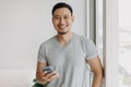 Young happy smiling asian man using smartphone feels relax and comfortable. Royalty Free Stock Photo